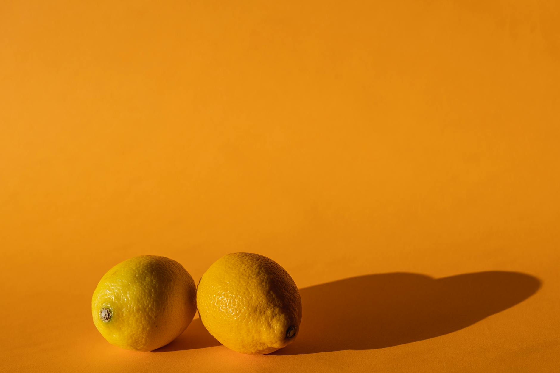 Blauer Vibrator umgeben von Blumen und Orangenscheiben auf gelbem Hintergrund